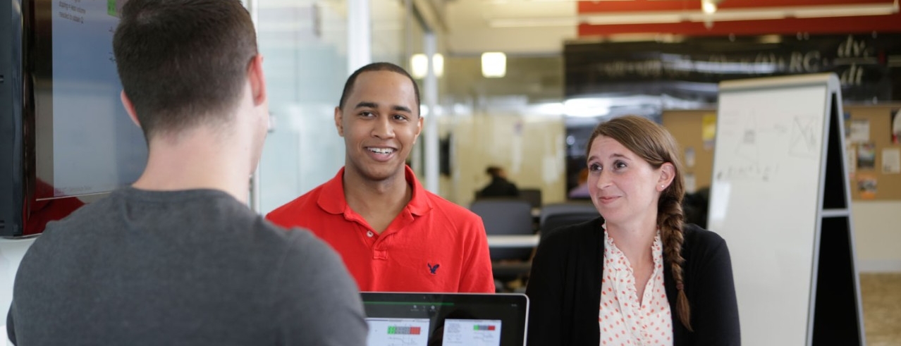 Group of three students in a classroom studying