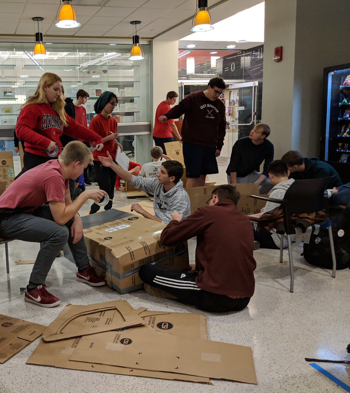 12 engineering students construct canoes from cardboard and tape