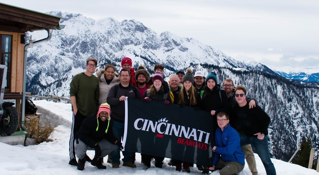 Students in the Bavarian Alps holding up a UC Bearcats flag