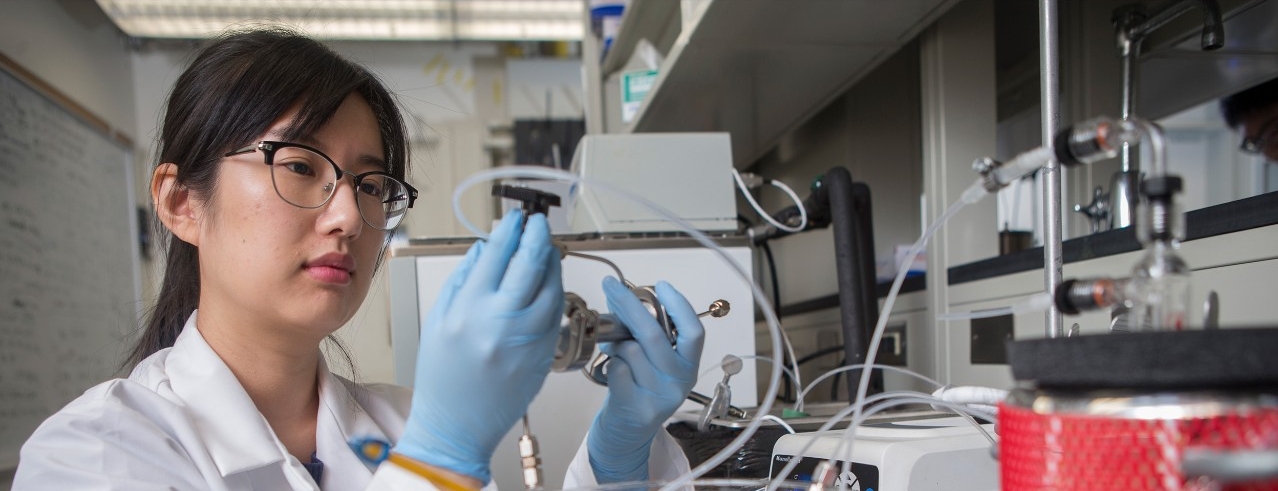 Student in a lab holding an instrument 