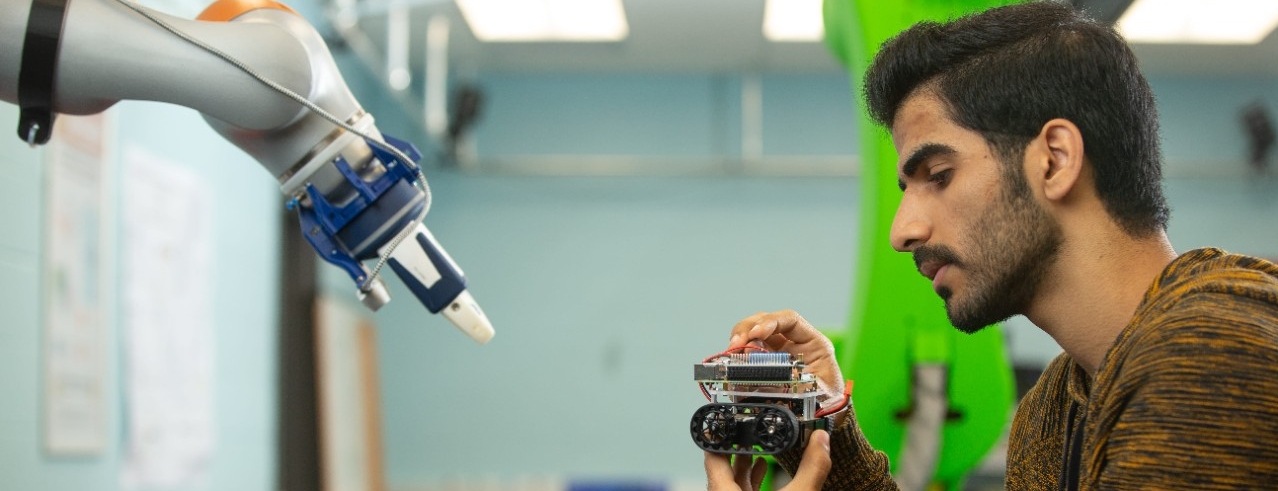 Student in robotics lab working on a mechanism 