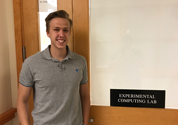 Caleb Van Haaren, computer engineering class of 2019, is pictured in front of the Experimental Computing Lab sign.