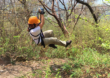 Gabrielle Notorgiacomo, biomedical engineering class of 2019, zip-lining through trees.