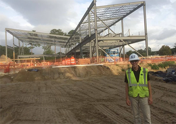 Timothy Jones, mechanical engineering class of 2019, pictured in a neon safety vest and hardhat at a wastewater treatment facility.